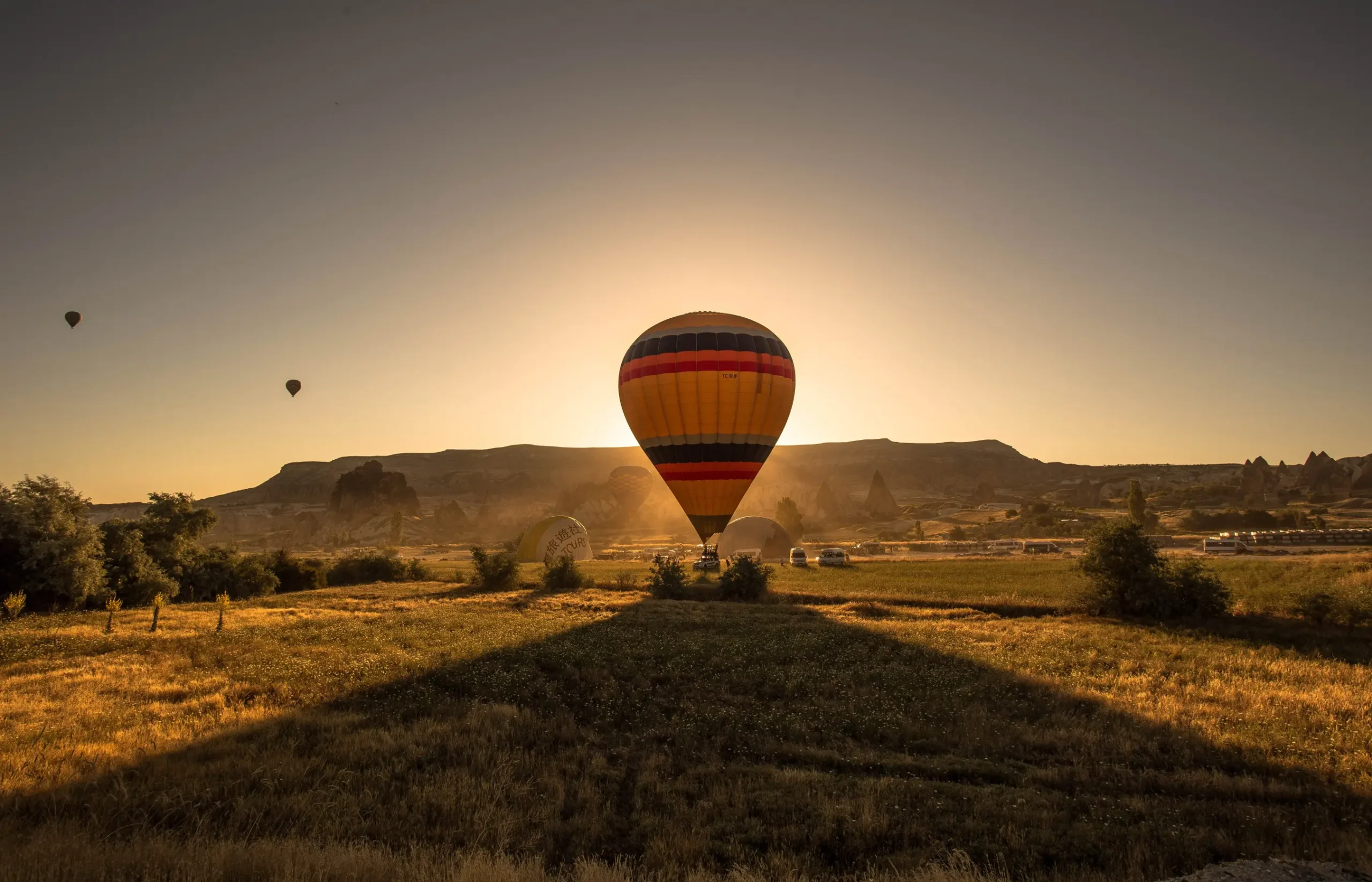picture colorful hot air balloon field surrounded by greenery mountains sunset scaled