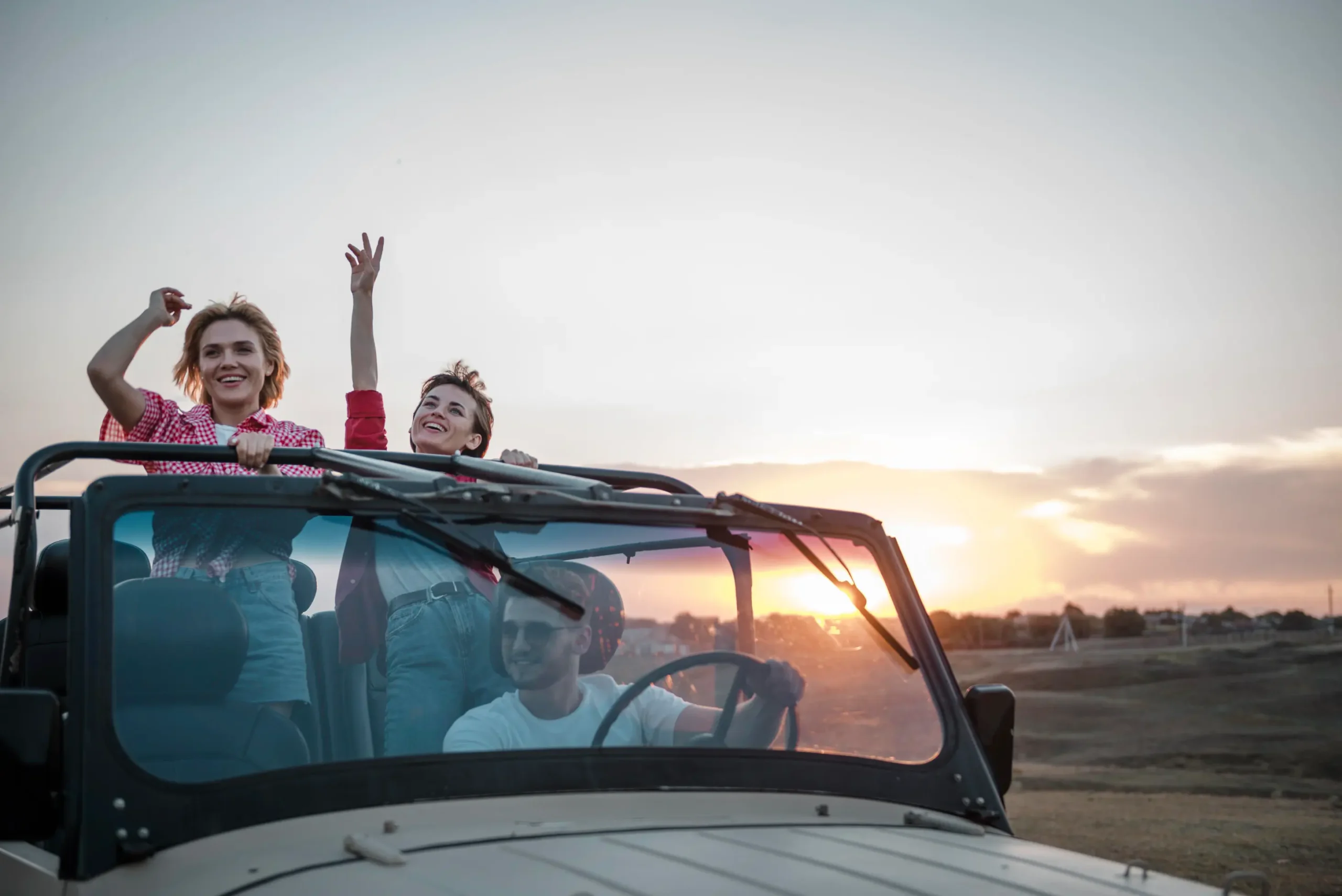 three friends traveling by car having fun scaled